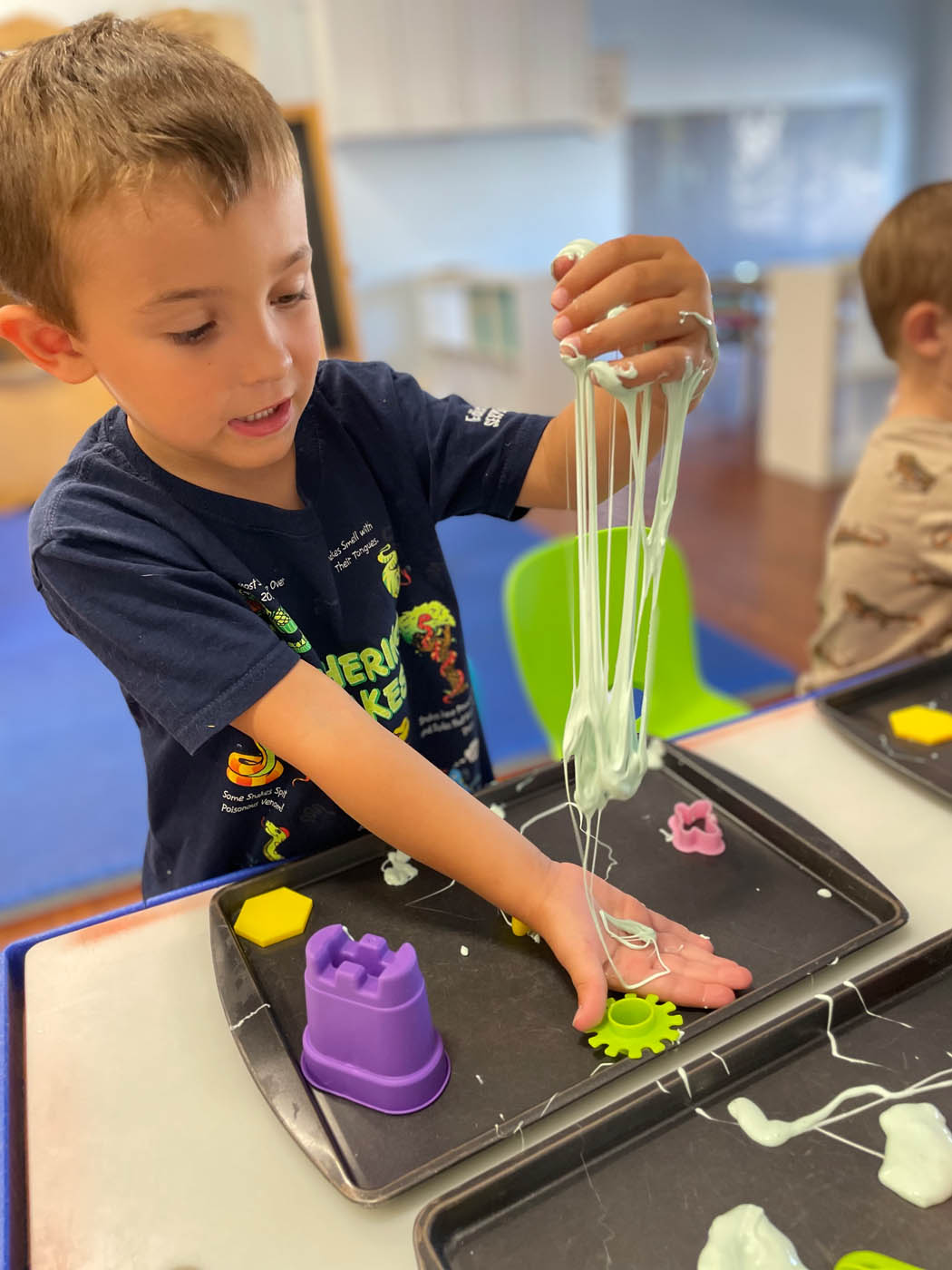 A little boy playing with slime at Kids Garden's in Columbia , SC.