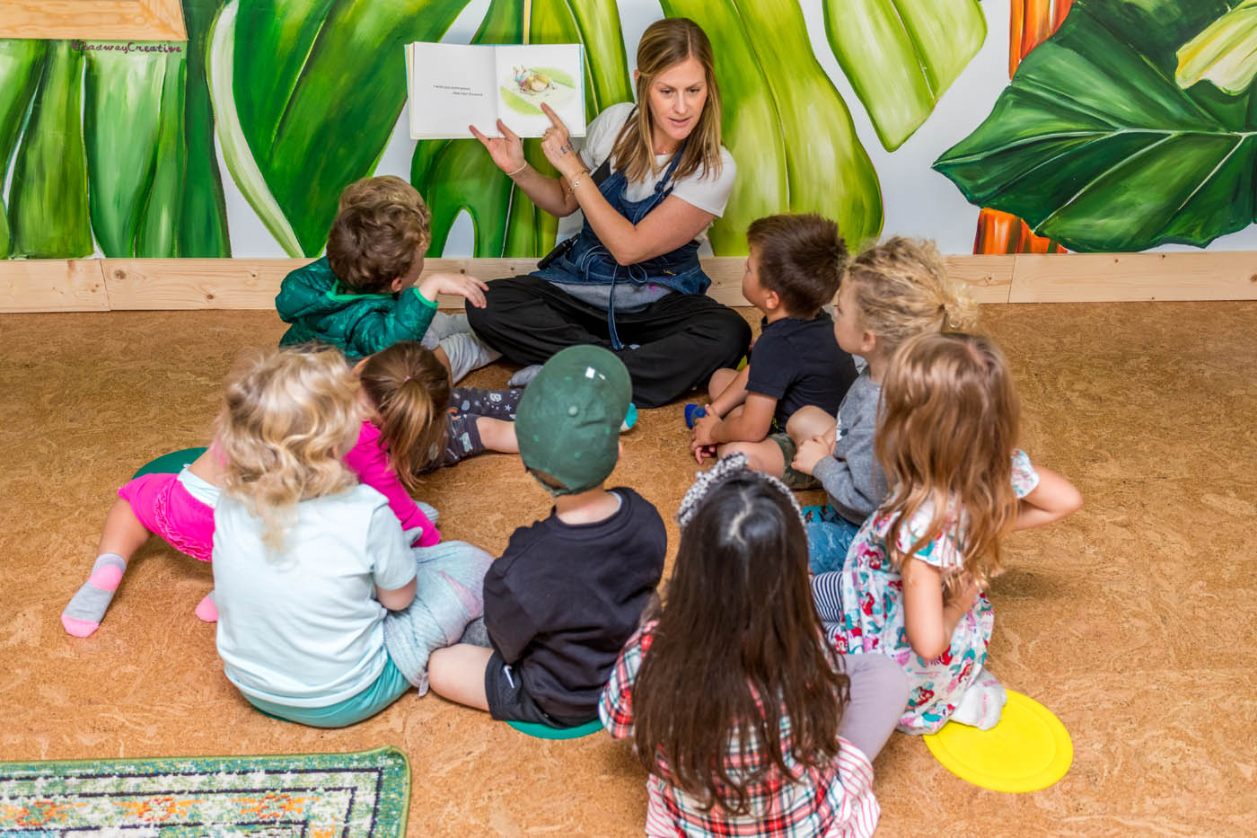 A teacher reading to a group of kids at Kids Garden's daycare and preschool in Mt. Pleasant, SC.