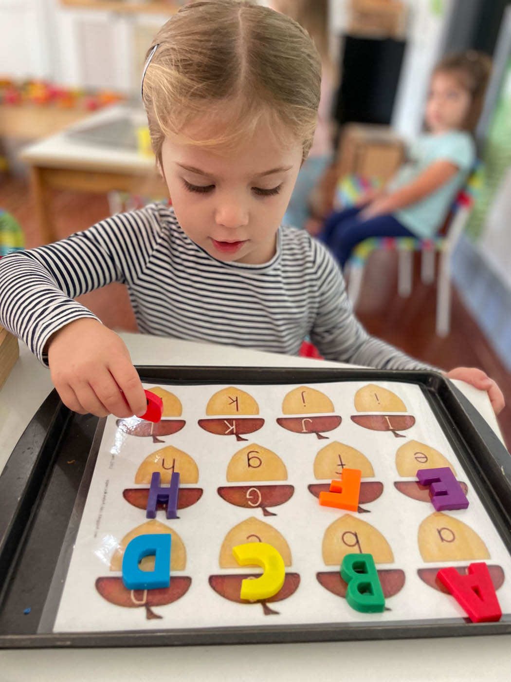 A little girl playing an alphabet game at Kids Garden.