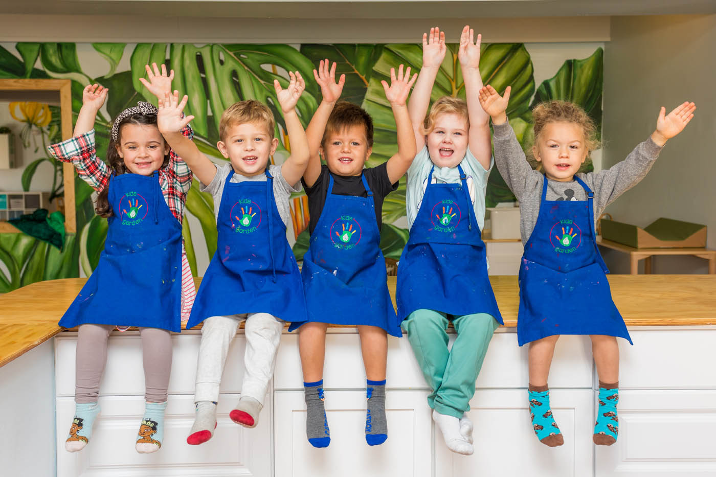 Kids in blue aprons at Kids Garden Evergreen learning center.