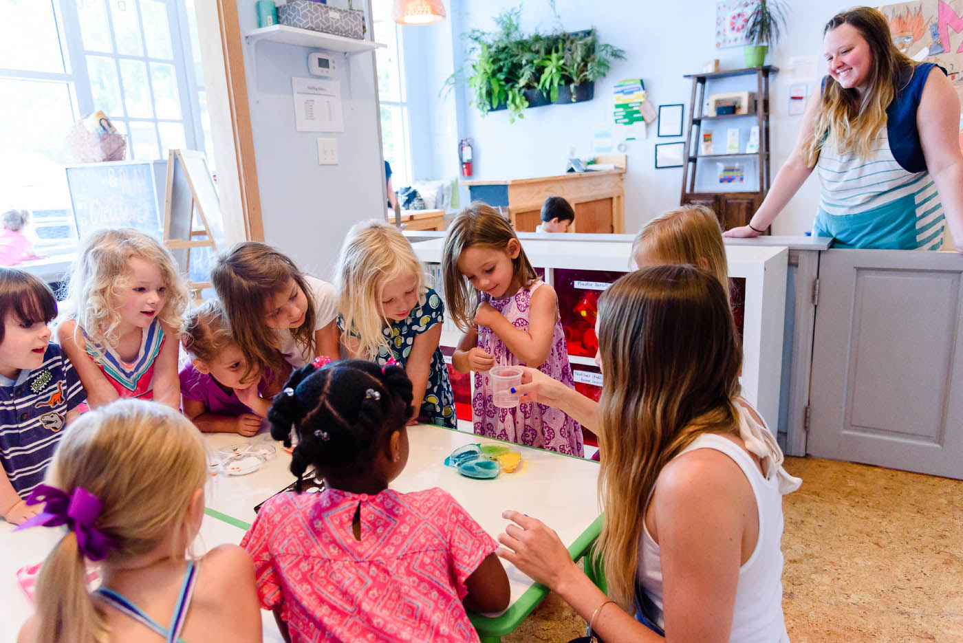 A teacher showing a group of kids arts and crafts at Kids Garden Steamboat Springs after school program in Steamboat Springs, CO.