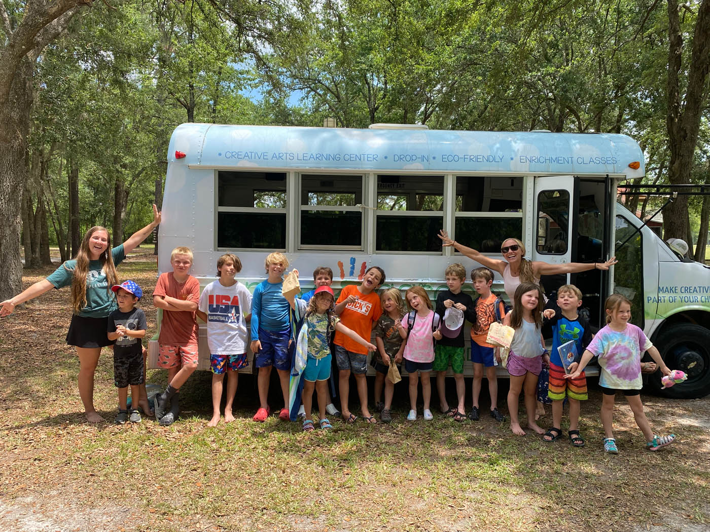A group of happy children at a Kids Garden Summerville summer nature camp.