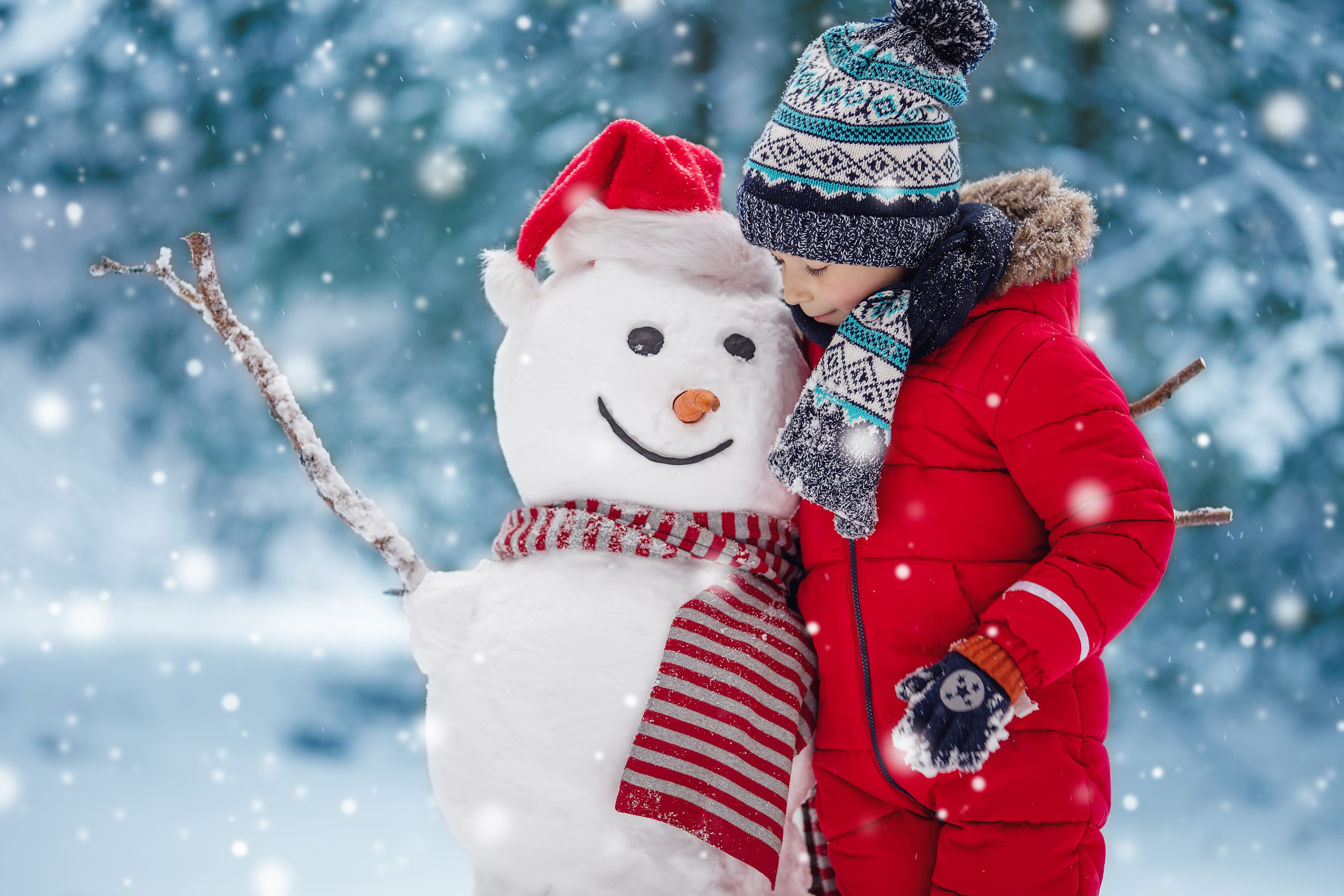 A young boy playing outside and building a snowman - The Importance of Outdoor Play in Winter. Kids Garden Charleston 